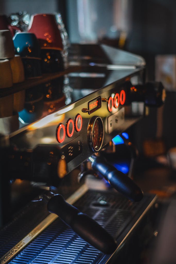 Detailed shot of a sleek espresso machine with vibrant buttons in a cozy cafe setting.
